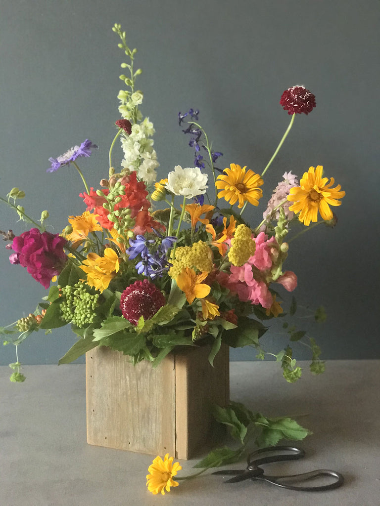 colorful summer flowers in a wildflowery style arranged in a wooden box