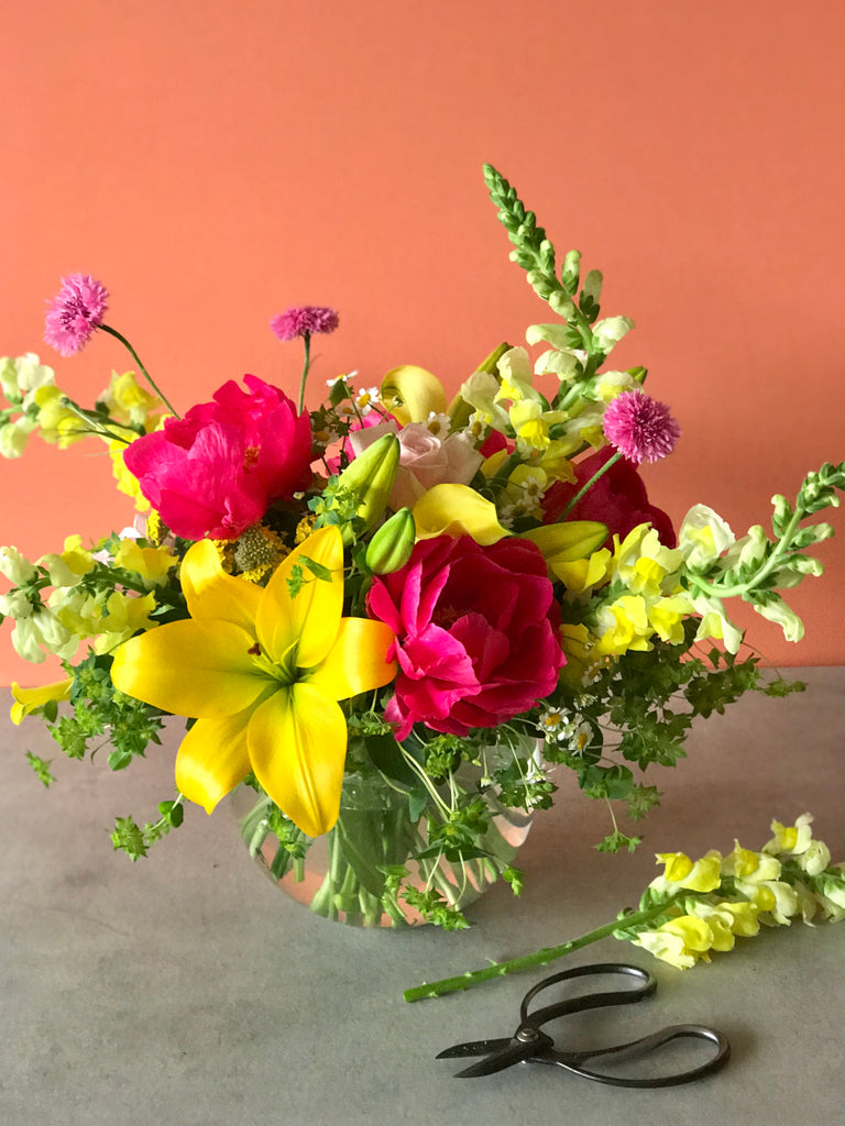 pink and yellow spring flowers arranged in a glass bowl, grown in Oregon